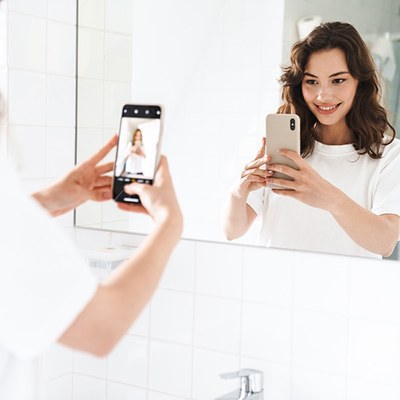 Schmuckbild: Person spiegelt sich beim Erstellen eines Selfies
